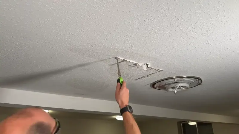 Water stain on a ceiling below a bathroom in a Commerce City home indicating an active leak from above