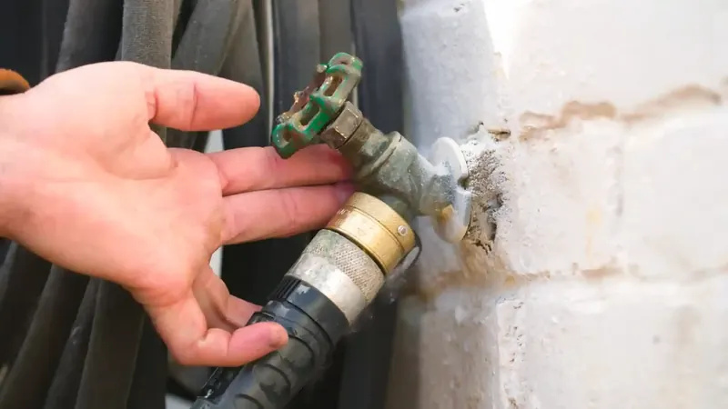 Exterior frost-free hose bib on a Commerce City home wall showing supply pipe connection at the exterior