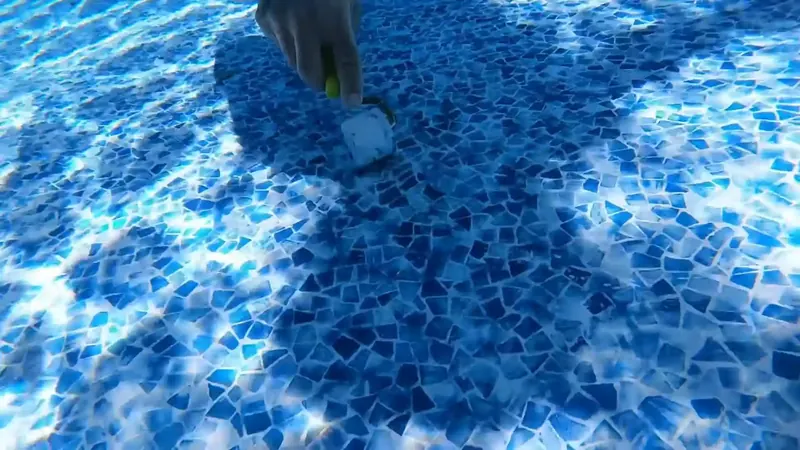 Pool water level drop visible at the tile line indicating an active leak in a Commerce City backyard pool