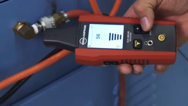 Ultrasonic transducer probe pressed against a wall surface detecting high-frequency leak signals in Commerce City